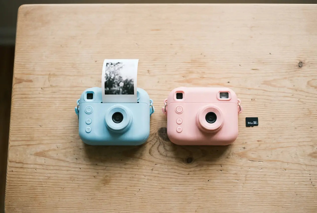 Deux appareils photo enfant côte à côte, l’un instantané avec un tirage, l’autre numérique avec une carte mémoire