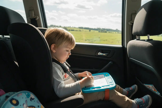 Enfant dessinant sur une ardoise magique de voyage en voiture