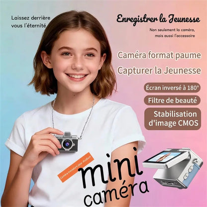 Jeune fille tenant un mini appareil photo numérique noir porté en collier, avec une vue rapprochée de l’écran rabattable.