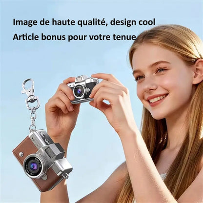 Jeune fille tenant un mini appareil photo rétro noir, à côté d’un modèle marron suspendu à un mousqueton.