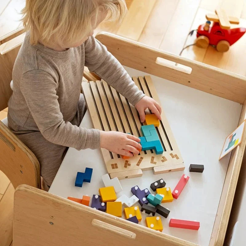 Enfant plaçant des blocs jaunes et turquoise sur le plateau d’un puzzle en bois posé à plat sur une table.